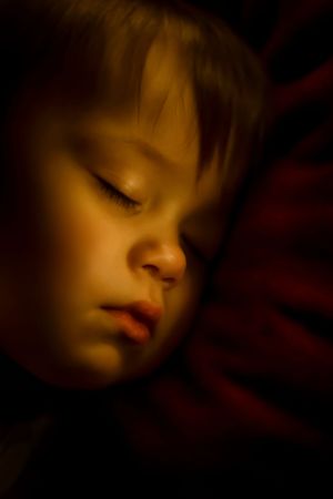 Soft lighting creates a dreamy atmosphere in a dark room with gentle shadows and warm tones.