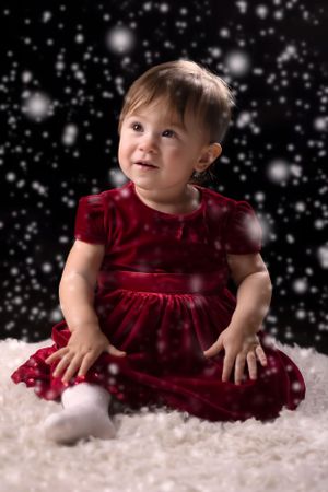 A festive holiday portrait with sparkling snowflakes against a black background.