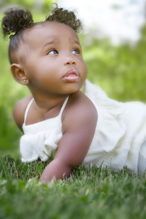 White dress contrasts beautifully against lush green grass in this outdoor portrait.