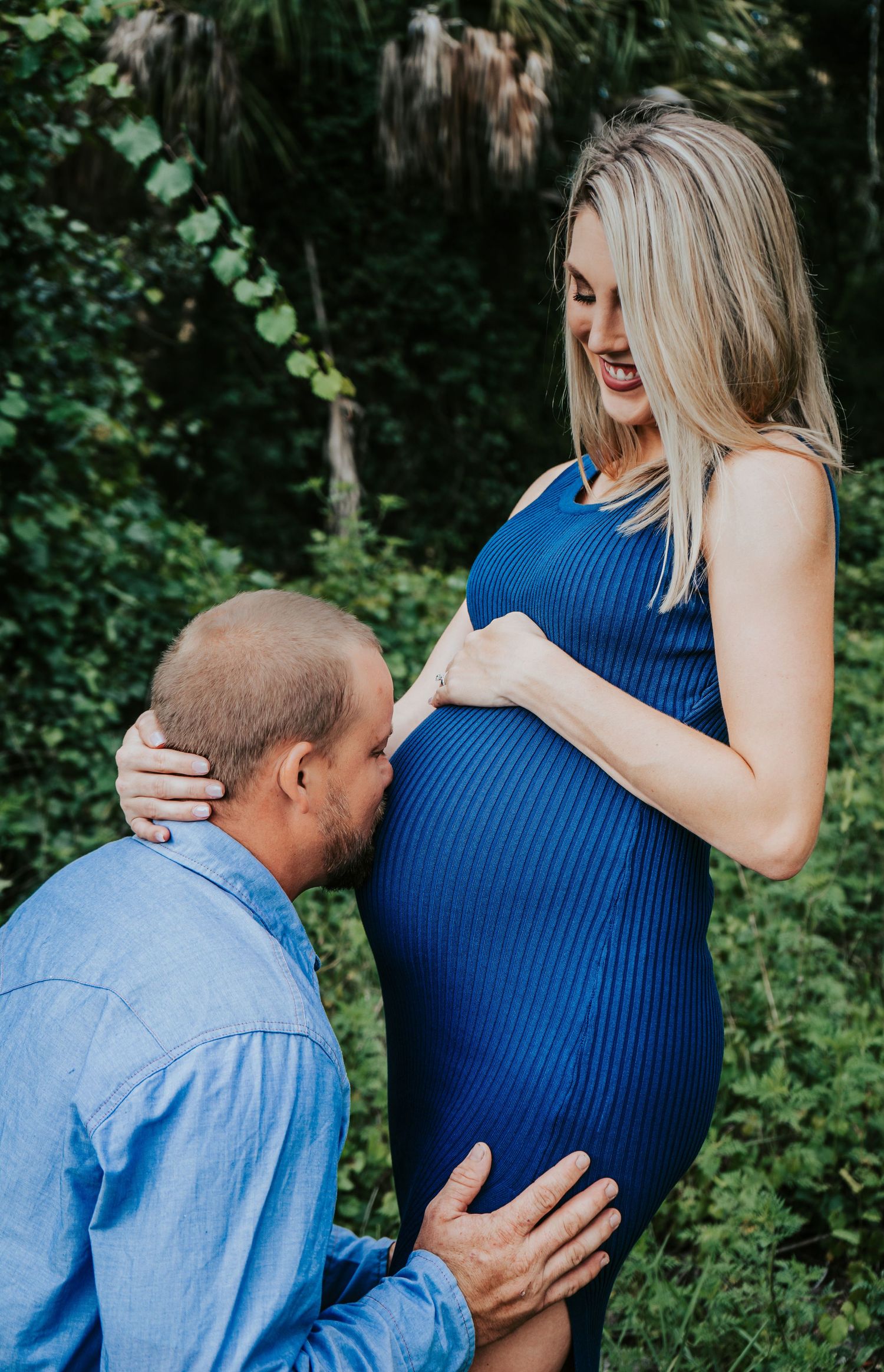Outdoor Maternity Session at Thatcher Park, Lithia, FL; father kissing wife's pregnant belly in the forest