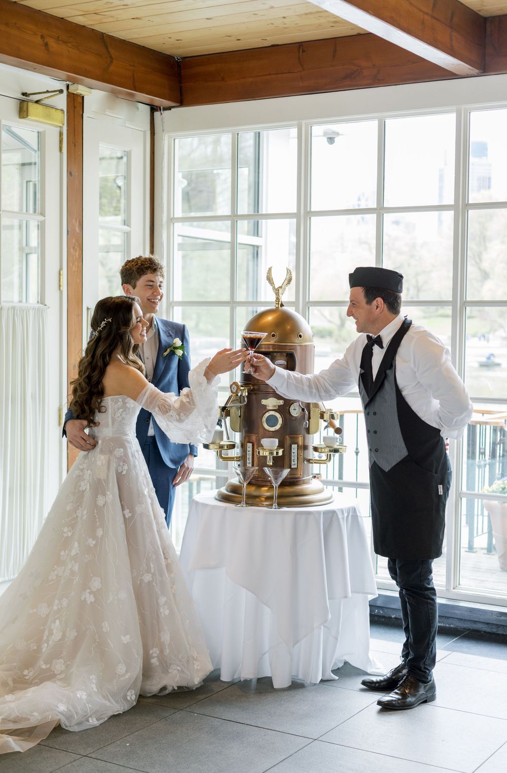 Wedding celebration features elegant vintage brass coffee service station with attendant serving newlyweds.