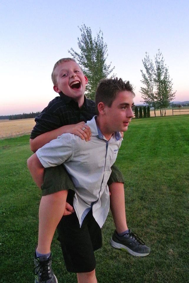 Joyful piggyback ride captured at sunset on a grassy field.