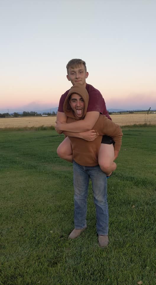 Playful piggyback moment captured at sunset in an open field.