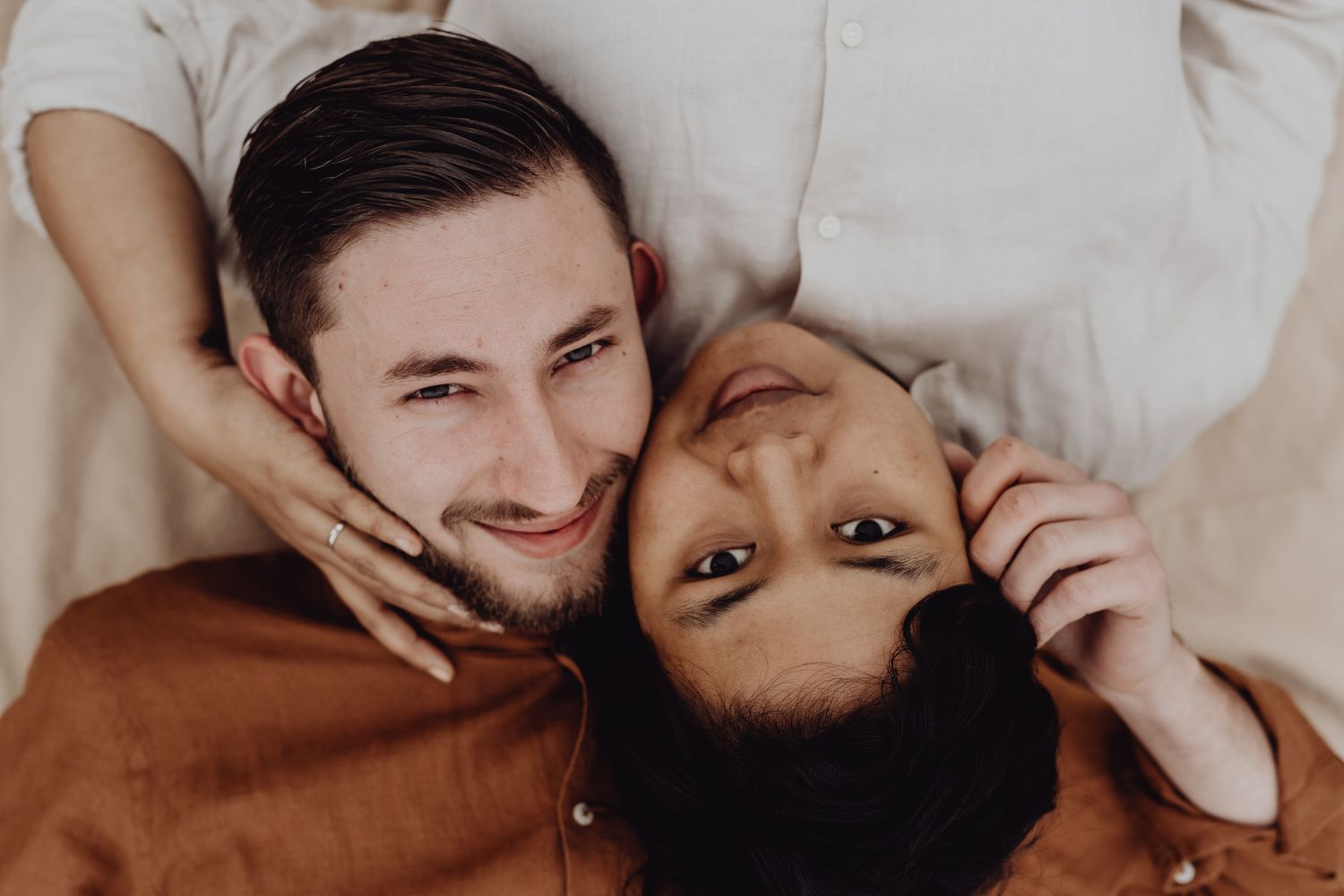 Intimate couple portrait taken from above with warm tones and soft lighting.