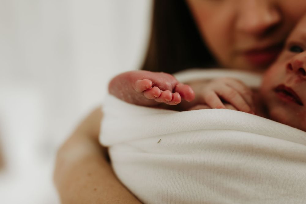 Close-up view of a tiny baby foot wrapped in white fabric.