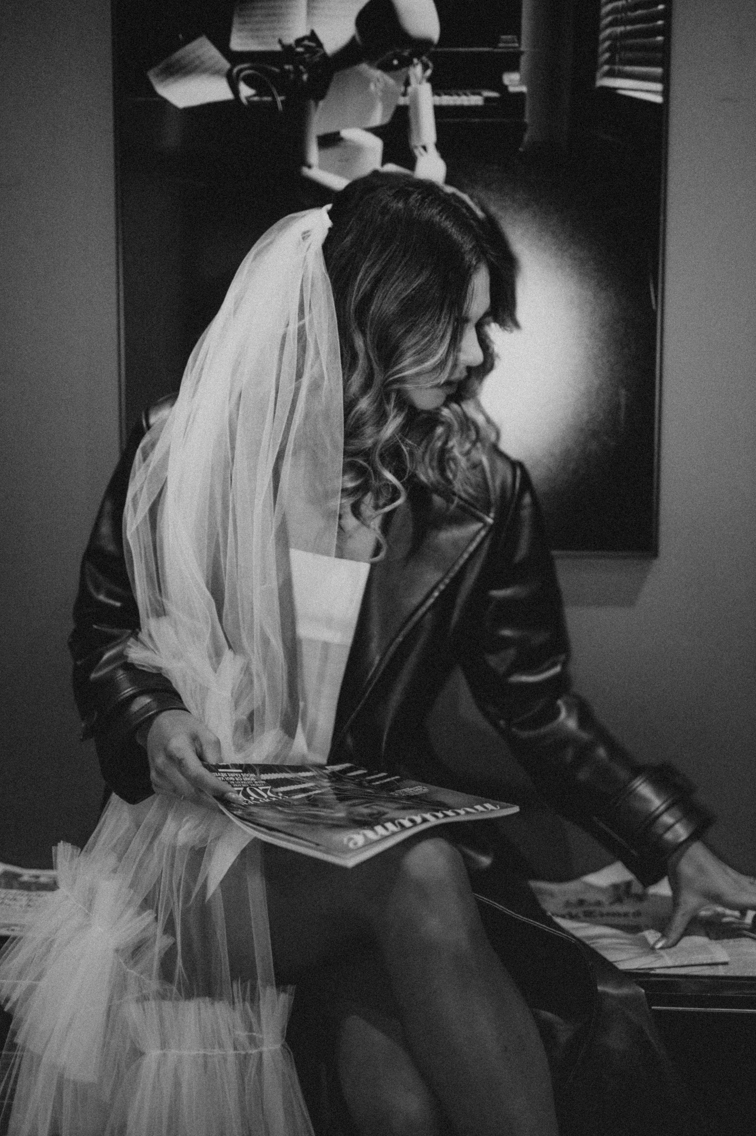 Monochrome fashion photography series with flowing white dress and leather accents.