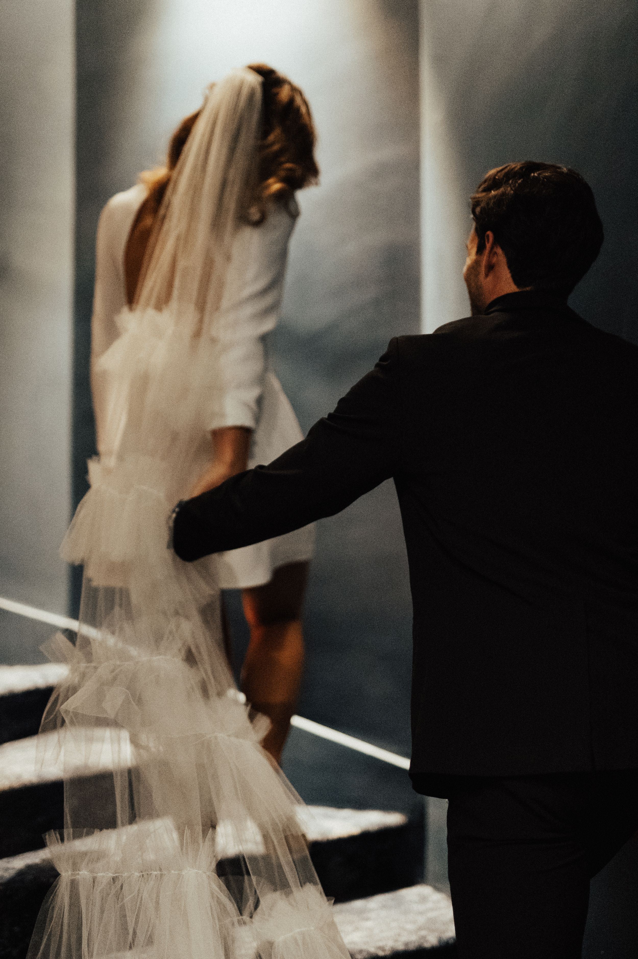 Dramatic fashion photography with flowing white dress and creative shadow play.