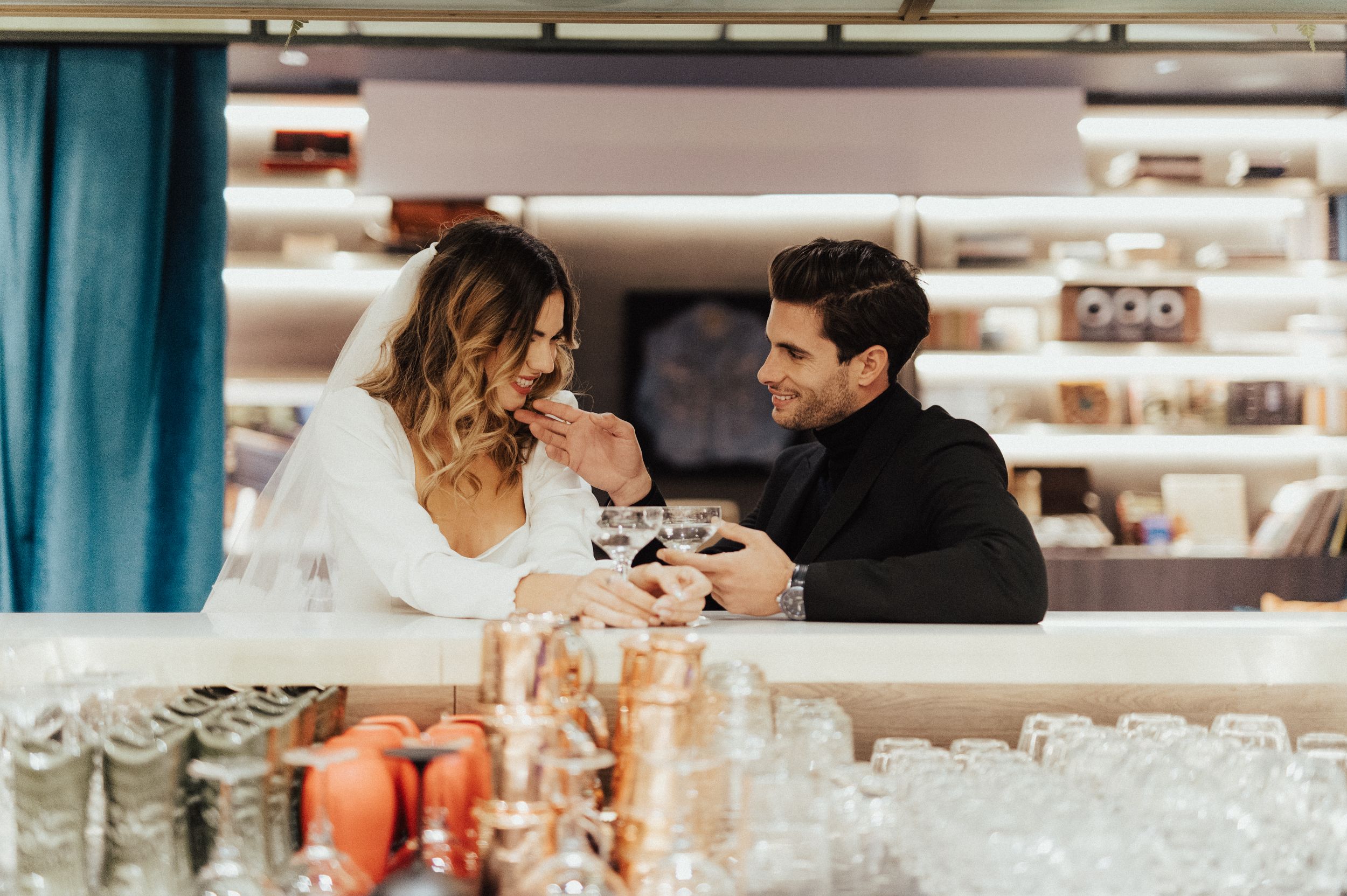 Modern wedding photoshoot in bright indoor space with bookshelves and decor.