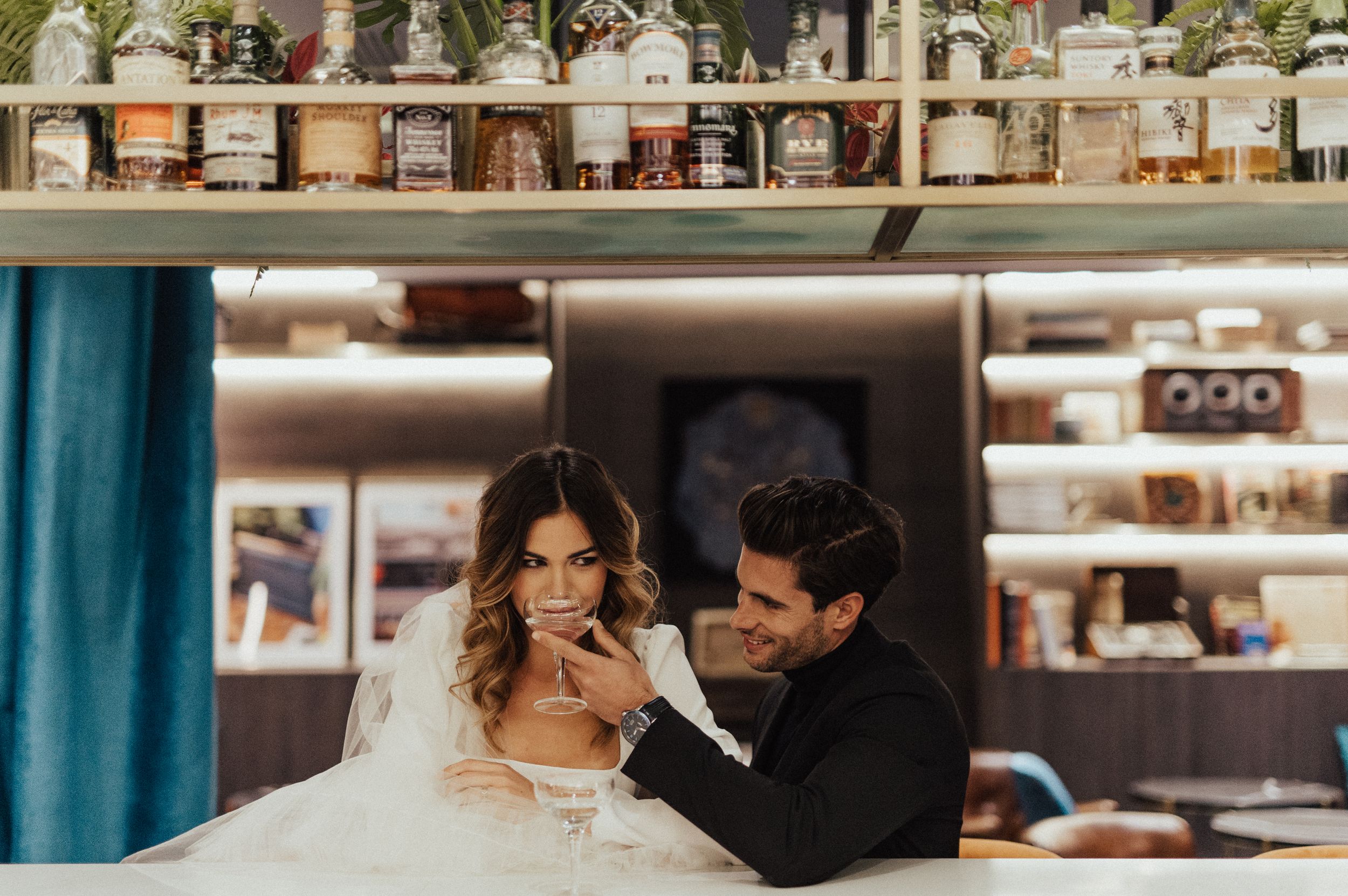 Wedding photoshoot in a modern indoor setting with shelves and decor.
