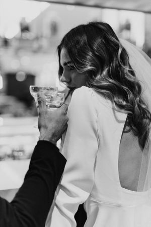 Intimate black and white wedding portraits showing couple sharing drinks.