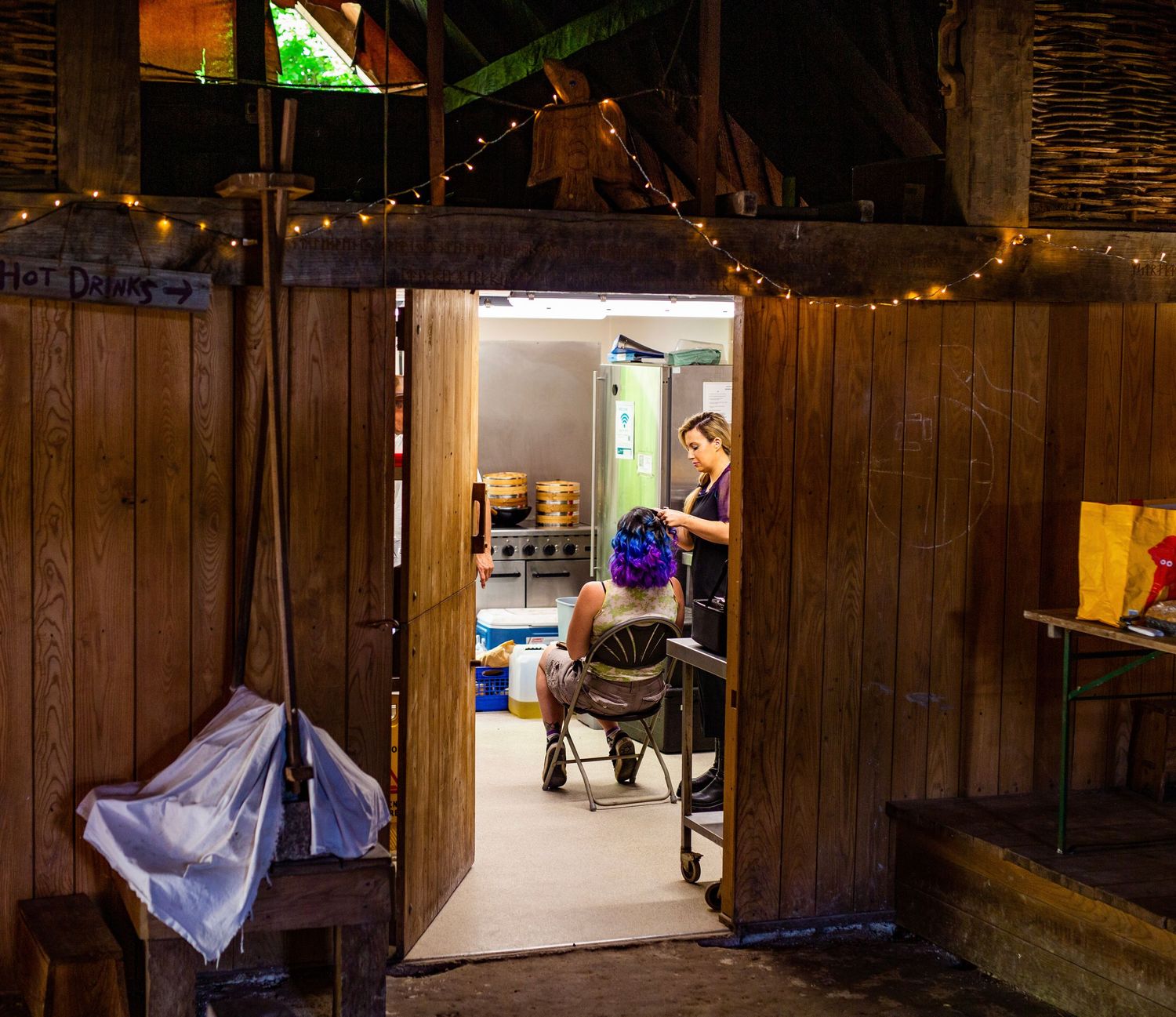 Rustic wooden barn interior with ambient lighting and exposed wooden beams.