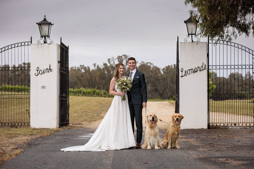 Bride and Groom sharing a moment together with their Golden Retriever dogs before their wedding ceremony at St.Leonards