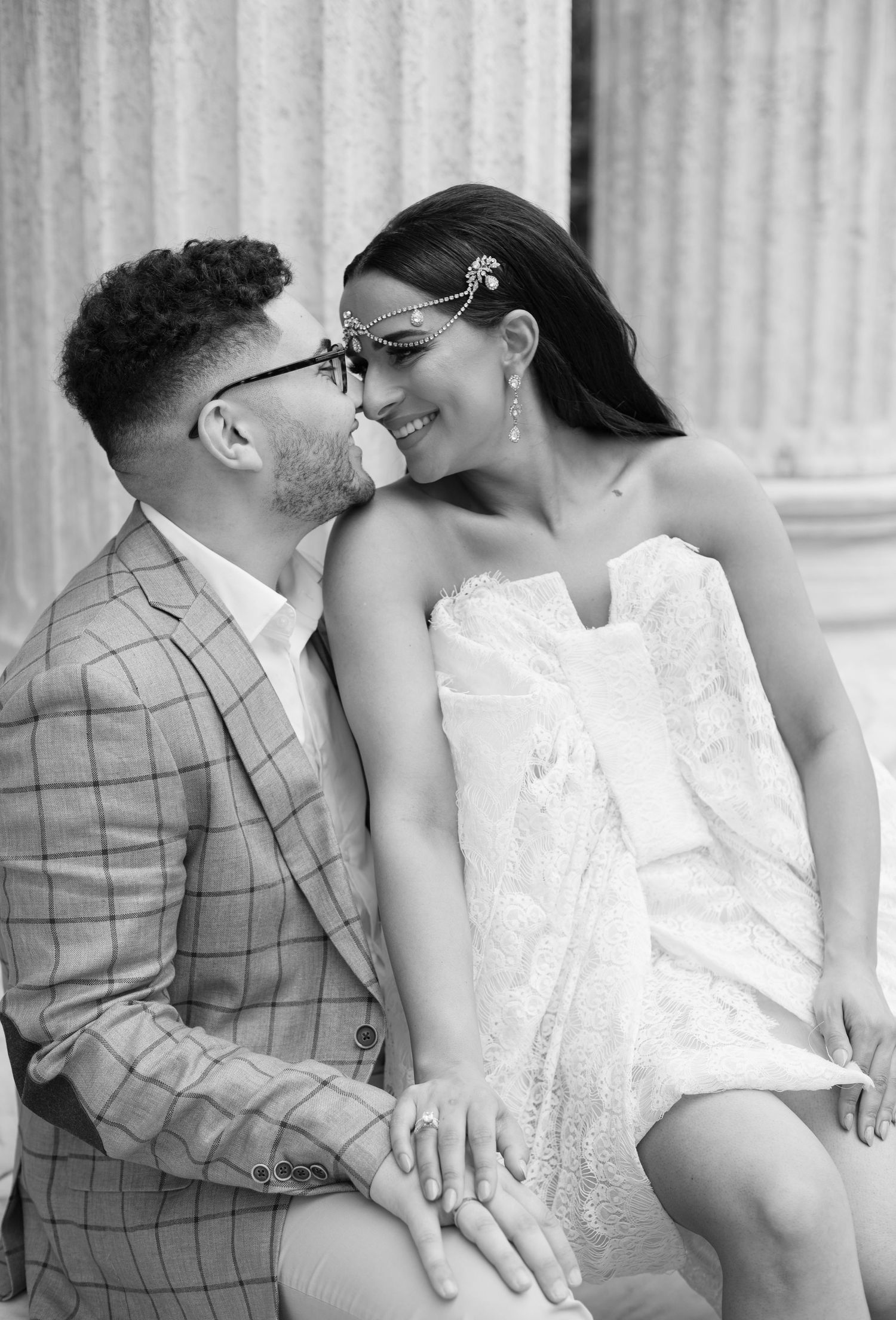 Black and white portrait of couple sharing romantic moment on stone steps.