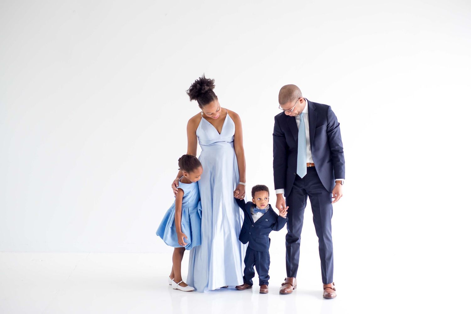 family taking pictures together in a white studio houston texas