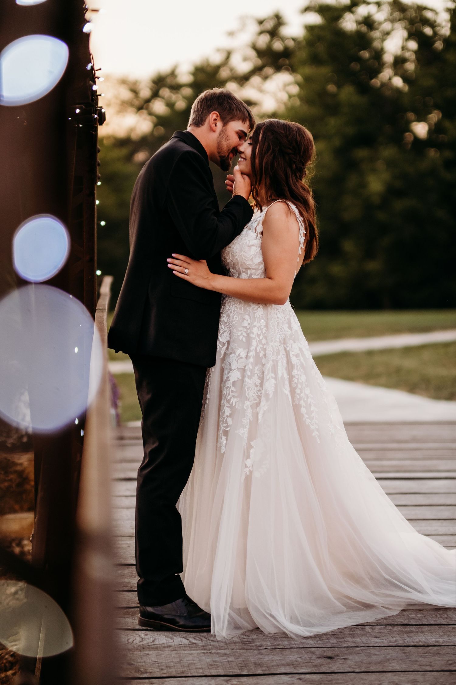 Couple kisses at sunset outside during wedding photography in Arkansas.