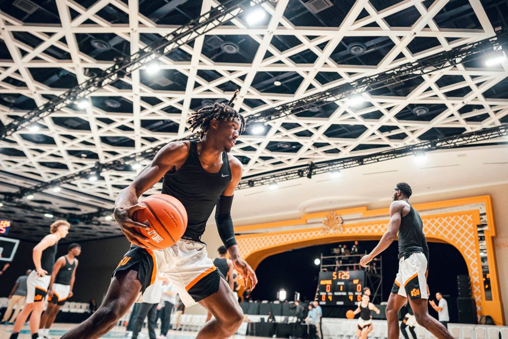 Basketball player drives to basket during indoor practice session.