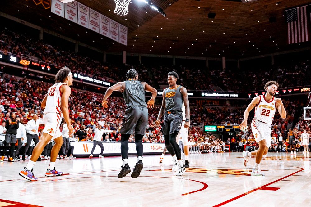 Basketball players in gray and white uniforms compete during a professional game.