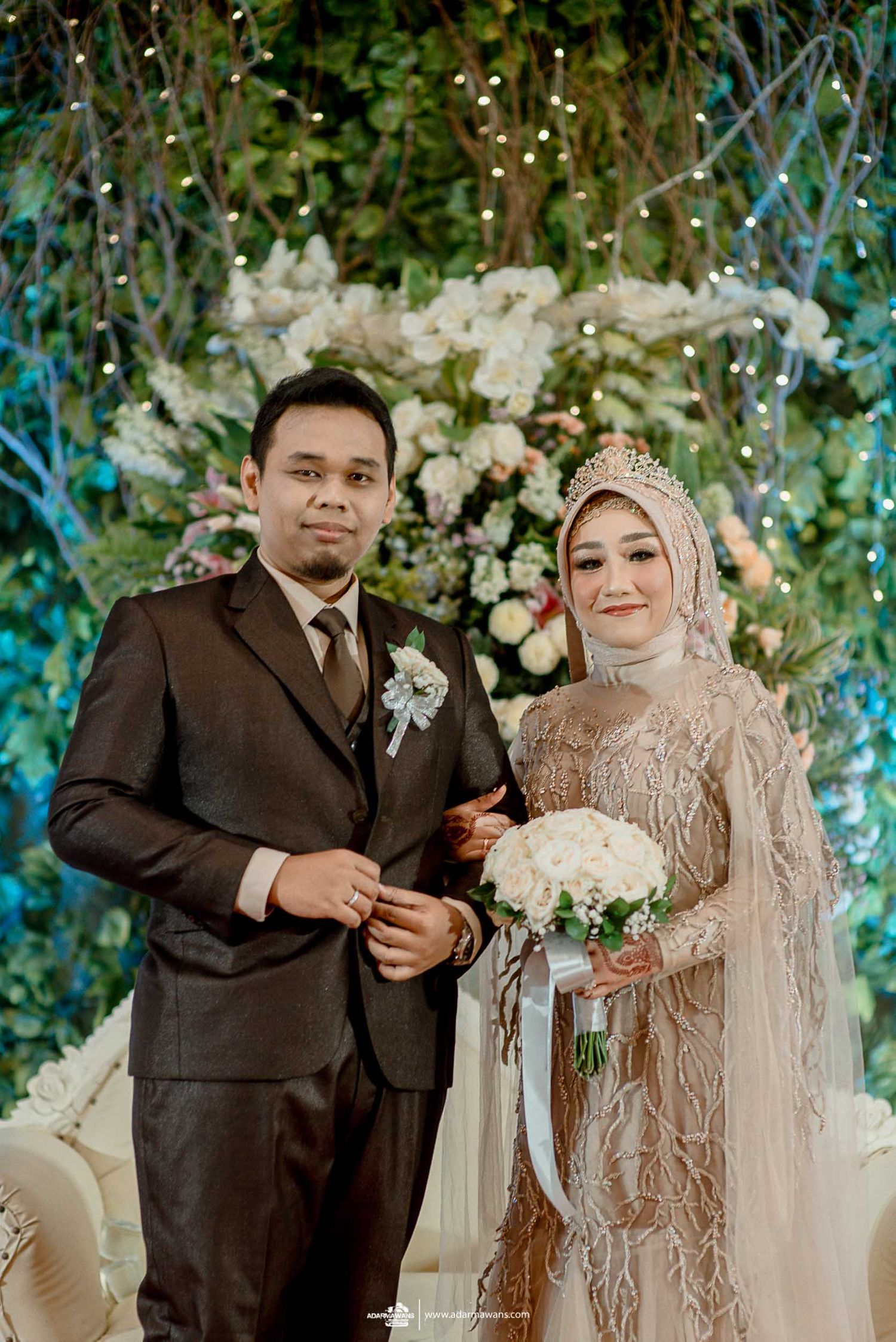 Elegant wedding portrait against a backdrop of white flowers and turquoise accents.
