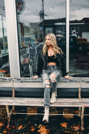 Casual fashion portraits on wooden deck with glass windows and autumn leaves.