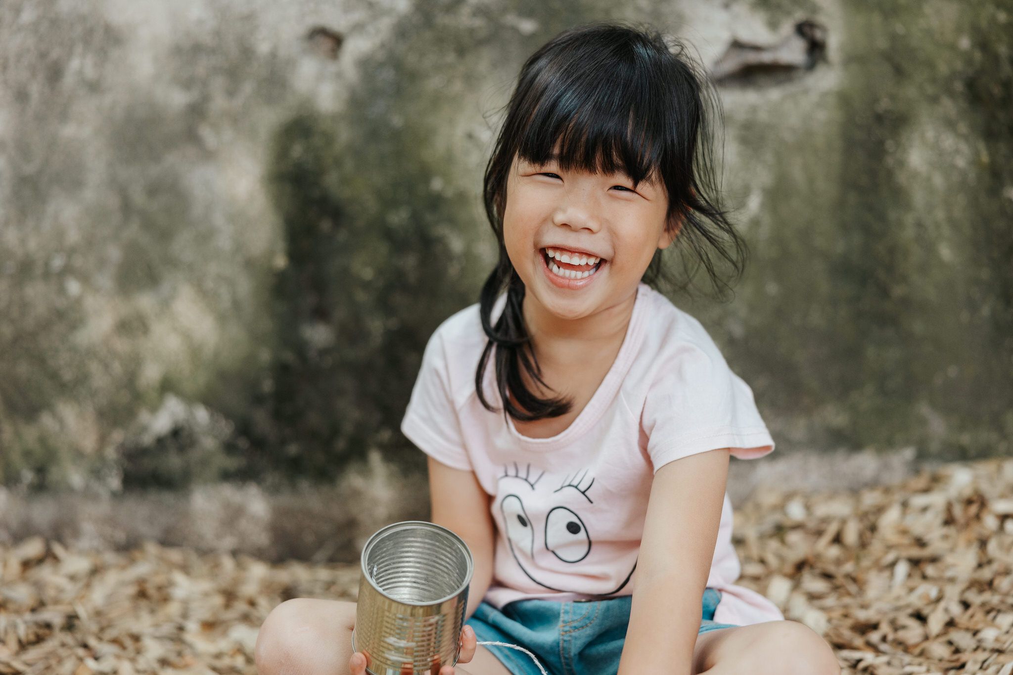 Playful outdoor photography session with children among fallen autumn leaves.