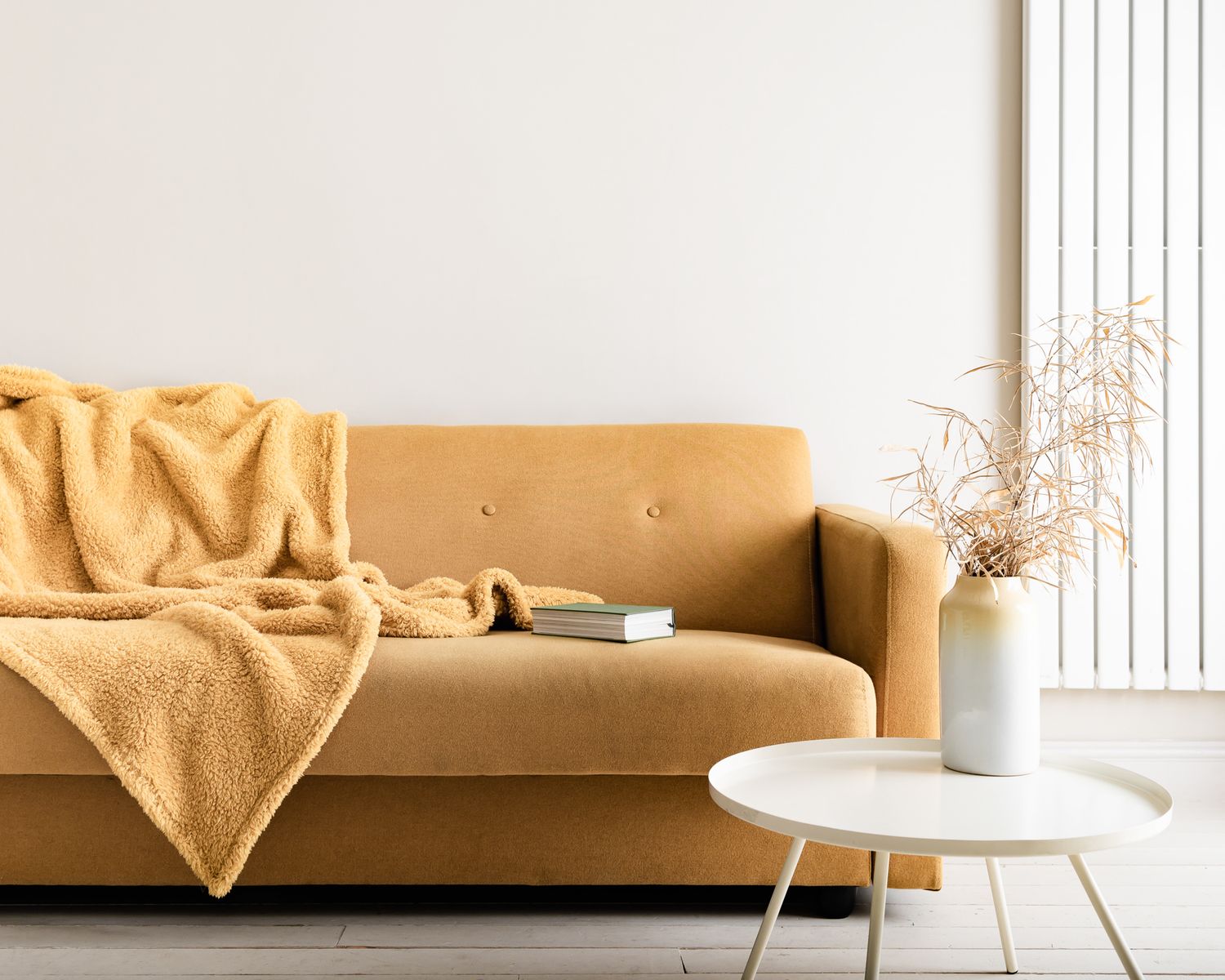 yellow sofa against a white wall, stylish, minimal, inviting. captivating airbnb photos