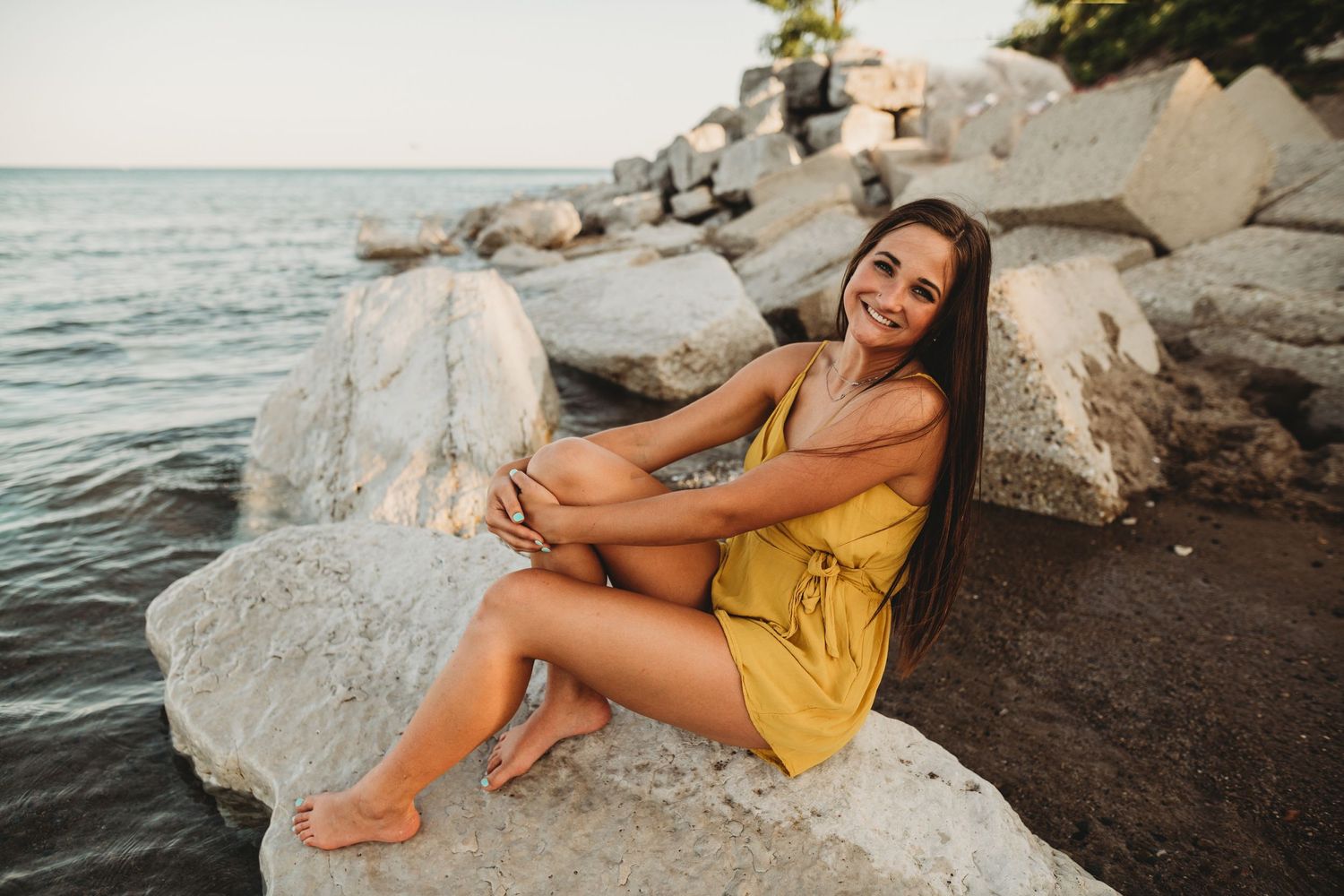Coastal photography session featuring rocky shoreline and water at sunset.
