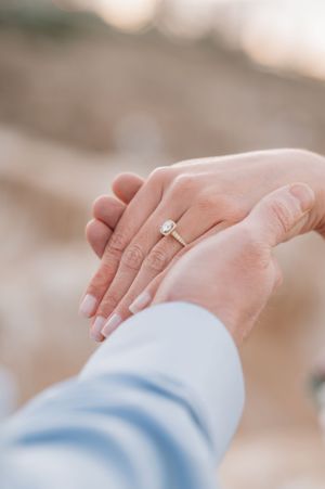 Close up of hands showing off a new engagement ring.