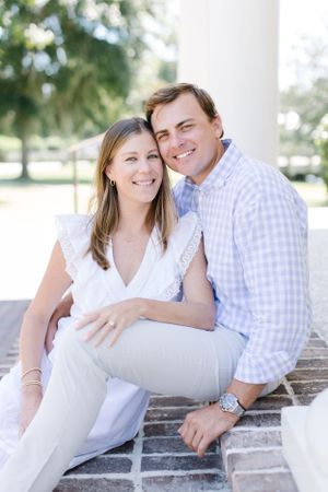 Casual portrait on brick steps with white column in background.