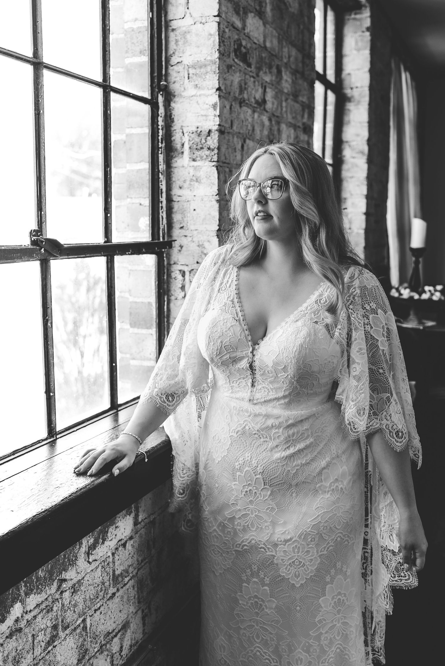 Artistic bridal portraits near window light showing details of a lace wedding dress.