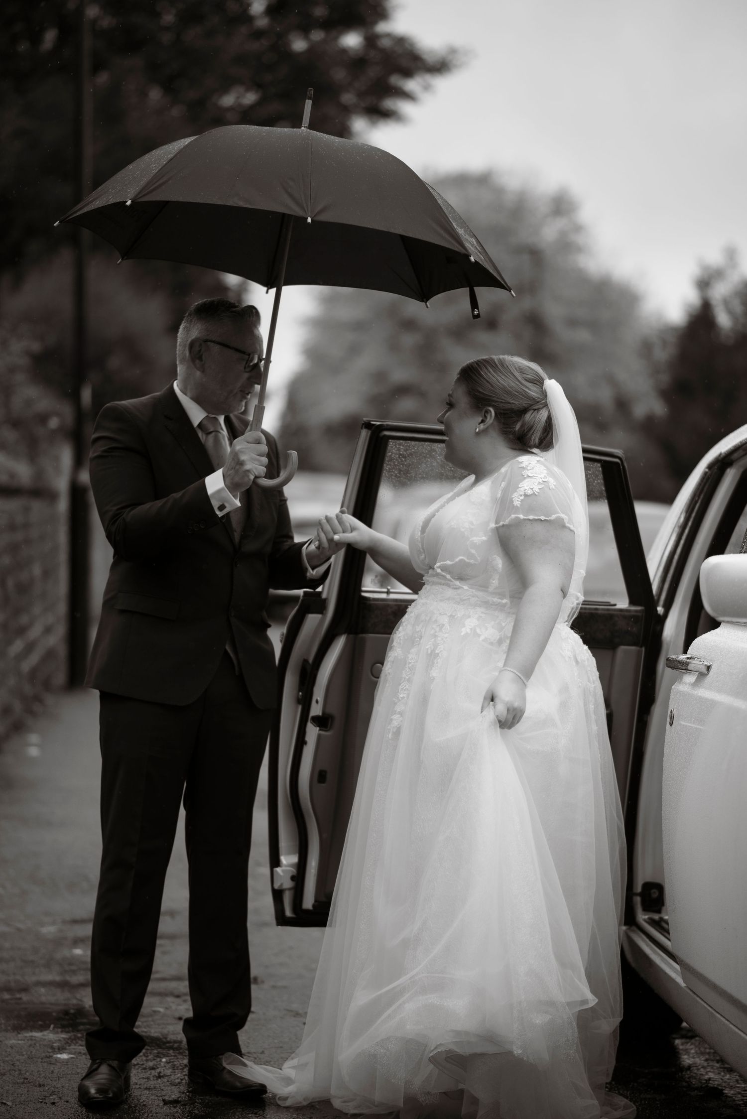 father of the bride helping his daughter out of a car on her wedding day, sheffield wedding