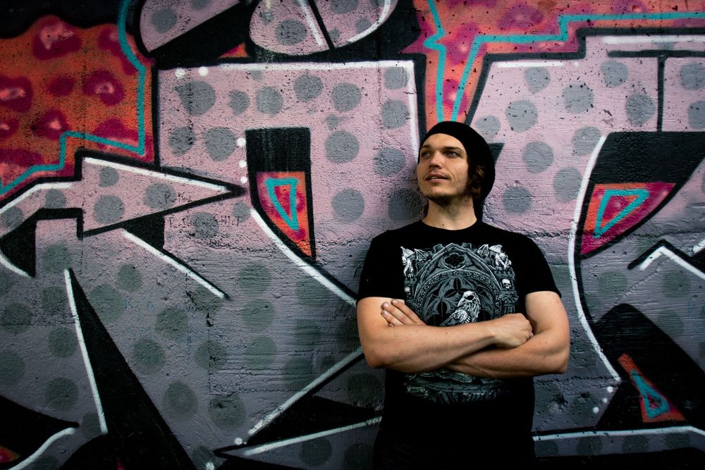 Urban graffiti wall with geometric patterns in gray and red tones.
