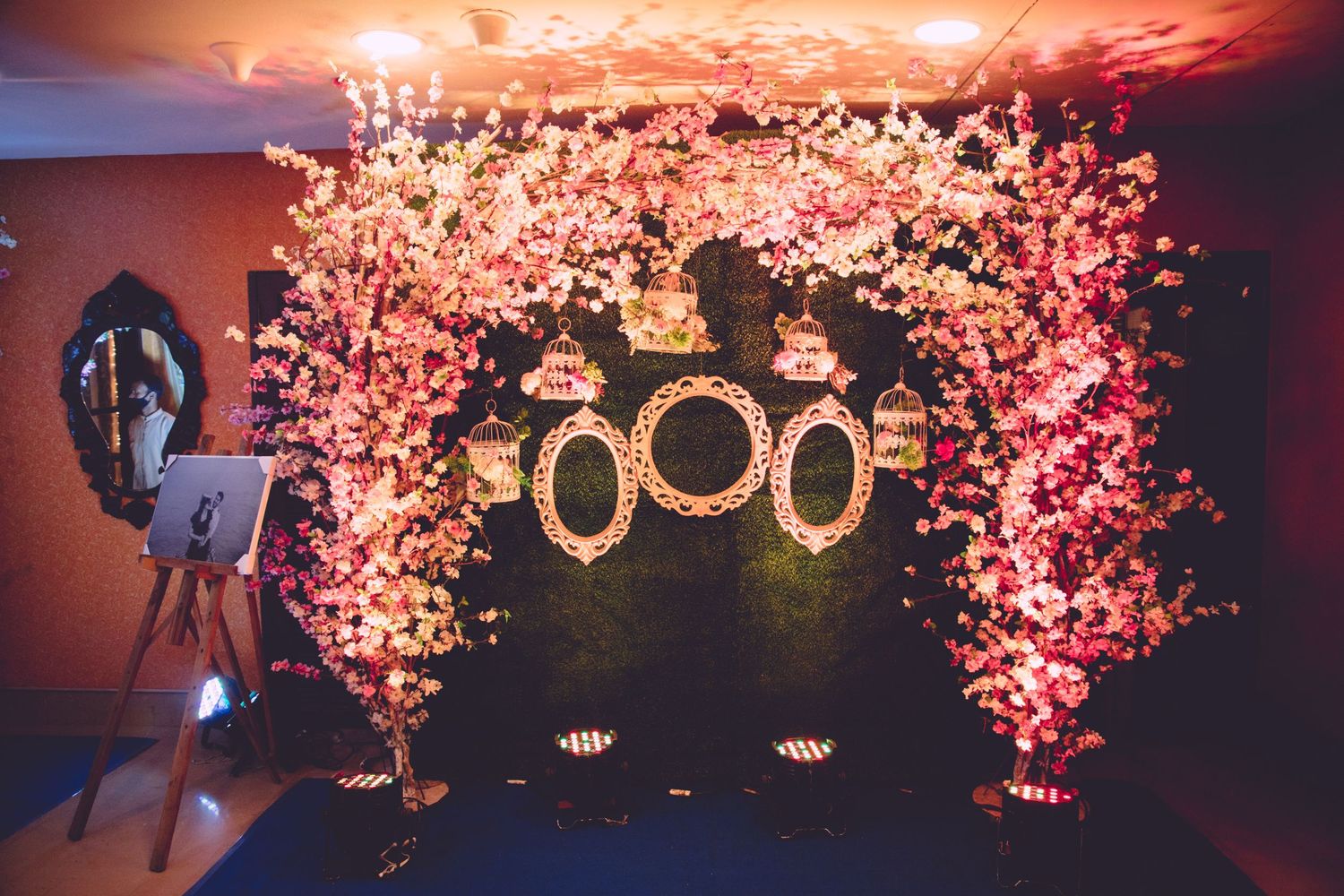Pink floral arch with illuminated decorative elements creates romantic wedding backdrop.