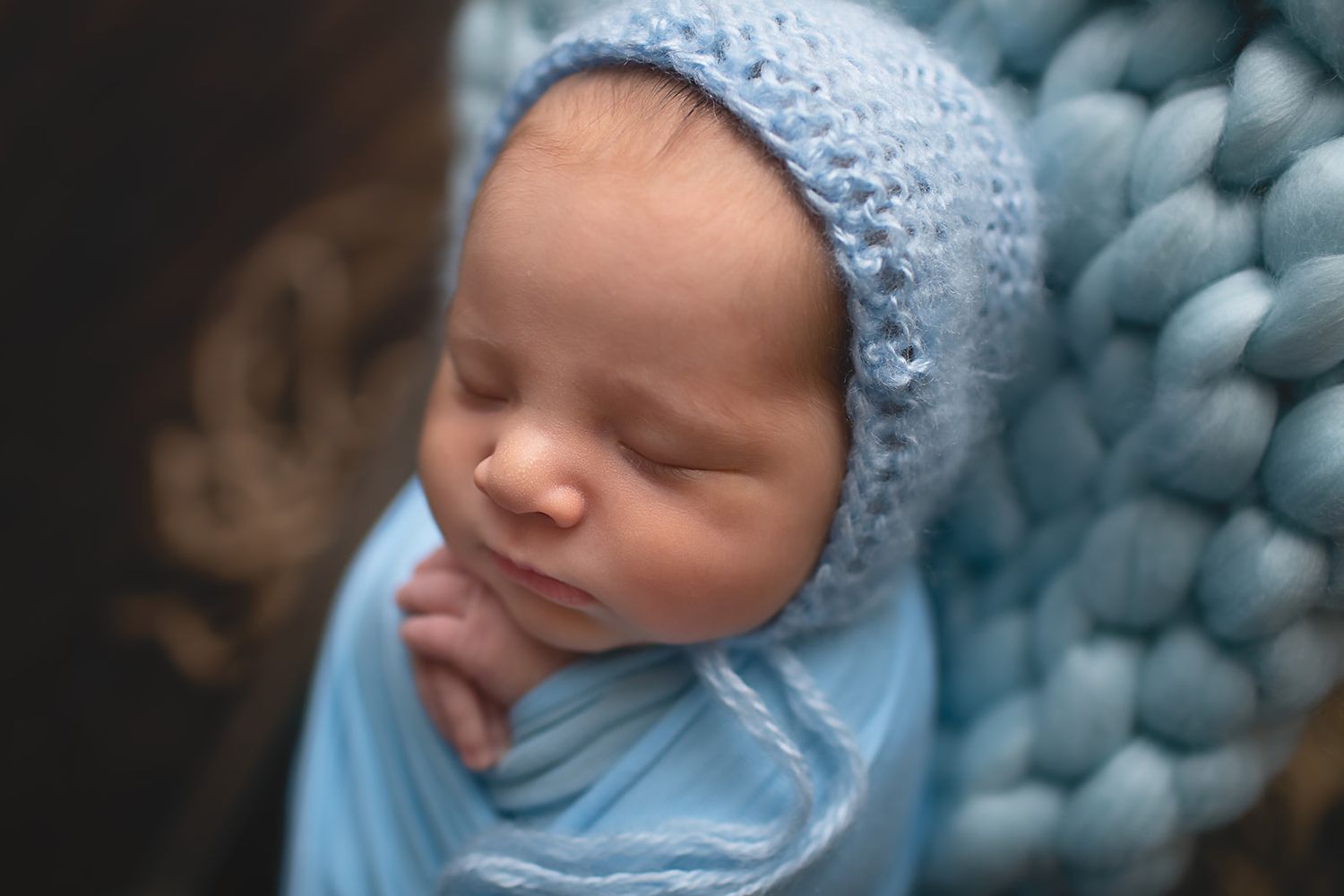 Newborn baby boy wrapped in blue wrap inin Alvin, Tx photography studio