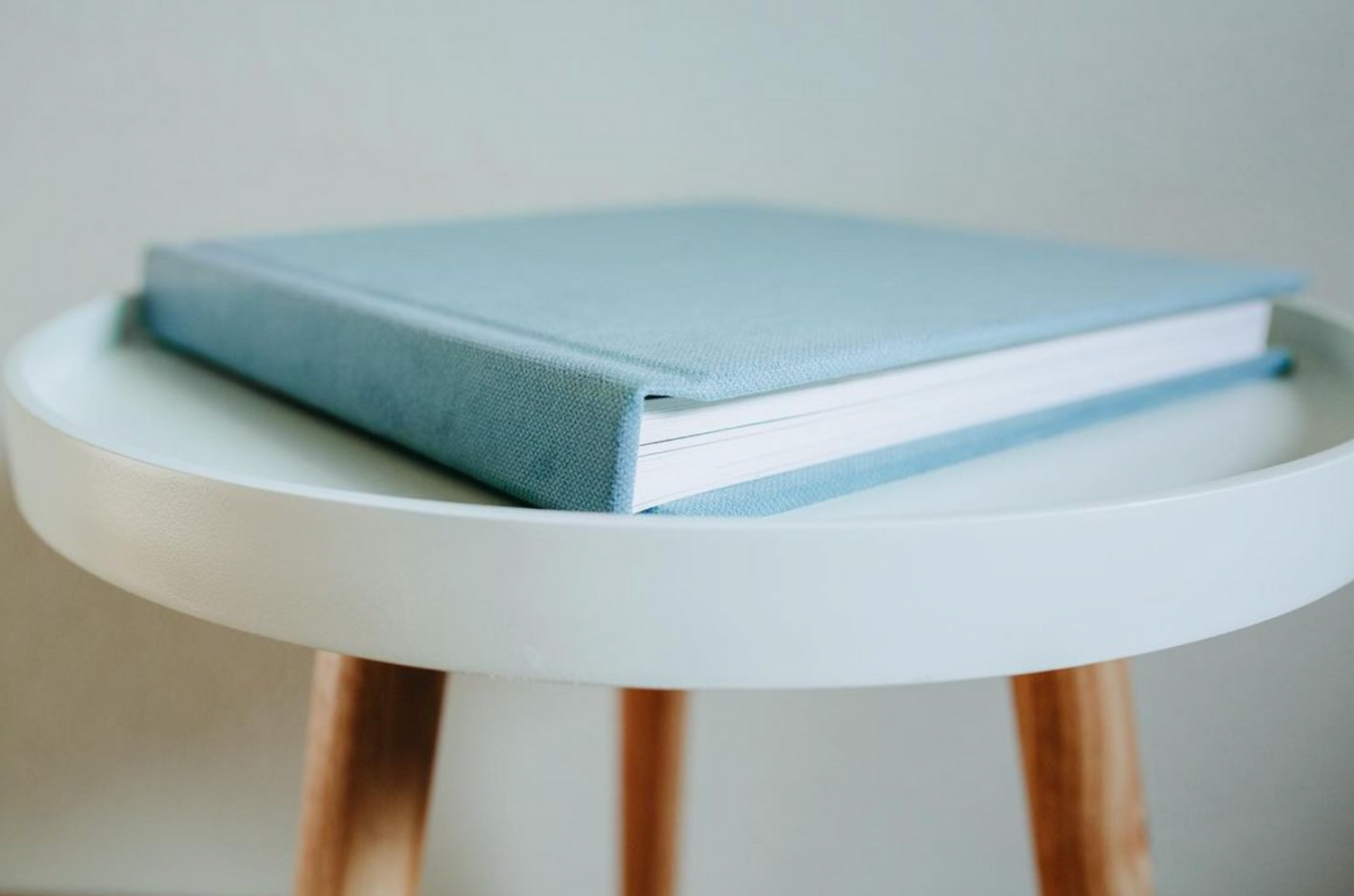 Light blue photo album displayed on white modern table.