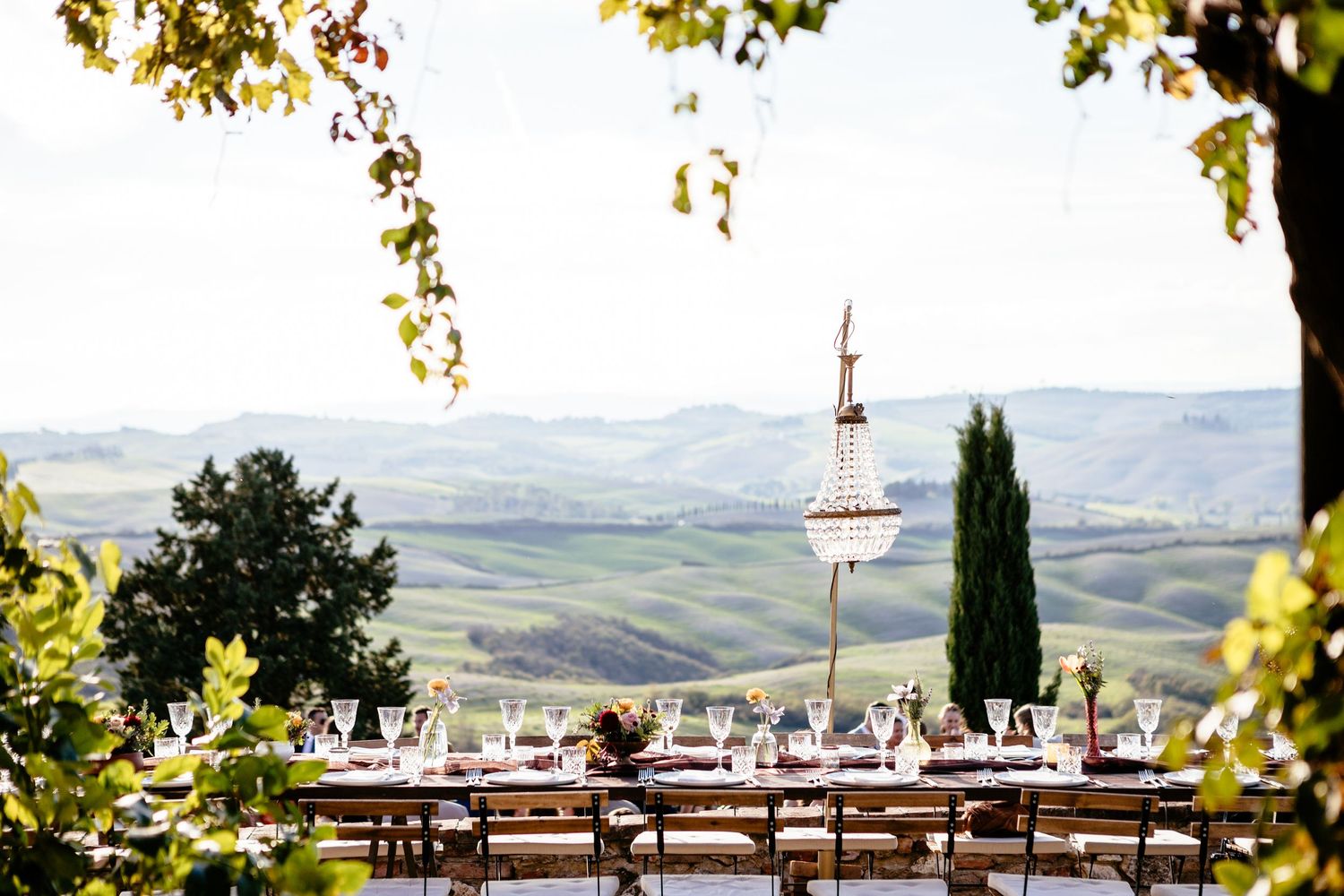 A table set for a wedding at The Lazy Olive with a view the Tuscan hills in the background.