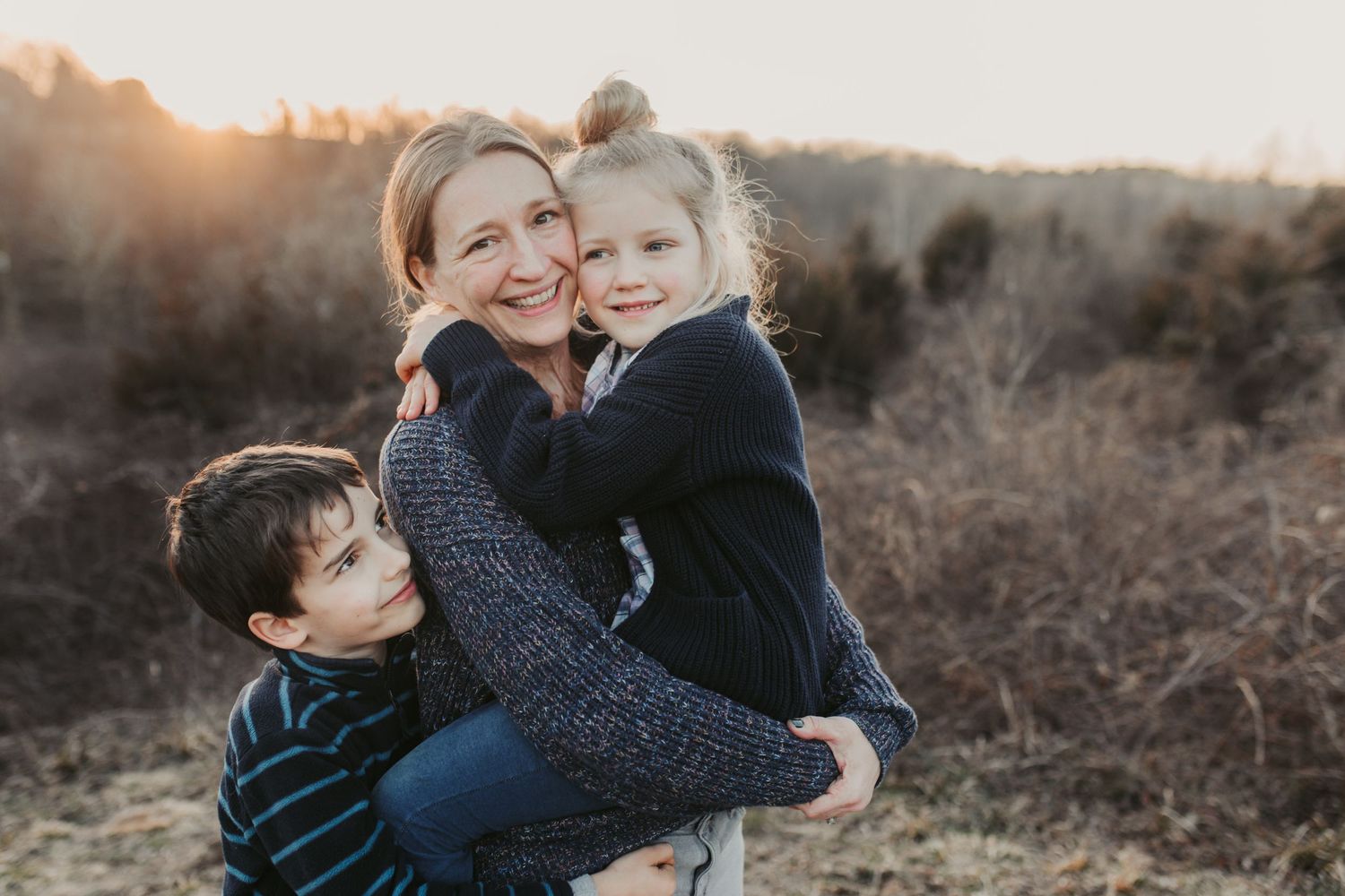A heartwarming family embrace captured outdoors during golden hour.