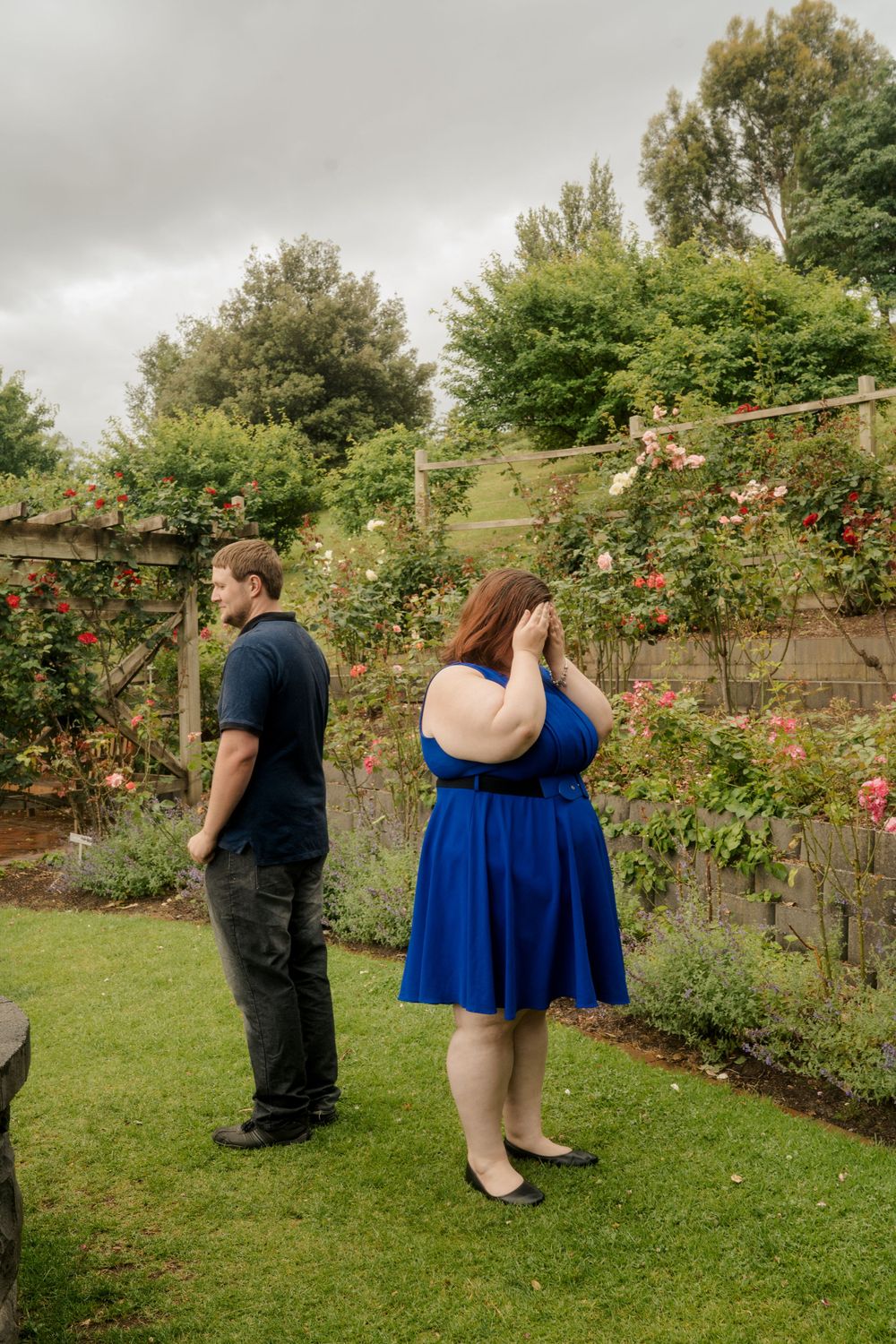 Plus size couple in park on cloudy day playing hide and seek