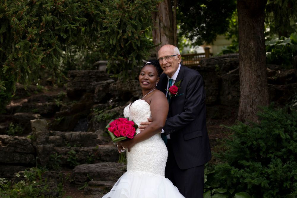 Groom behind bride looking at photographer