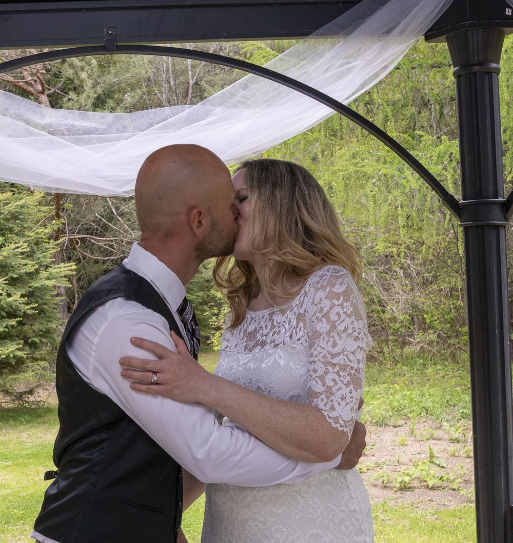 Bride and groom's first kiss in the archway
