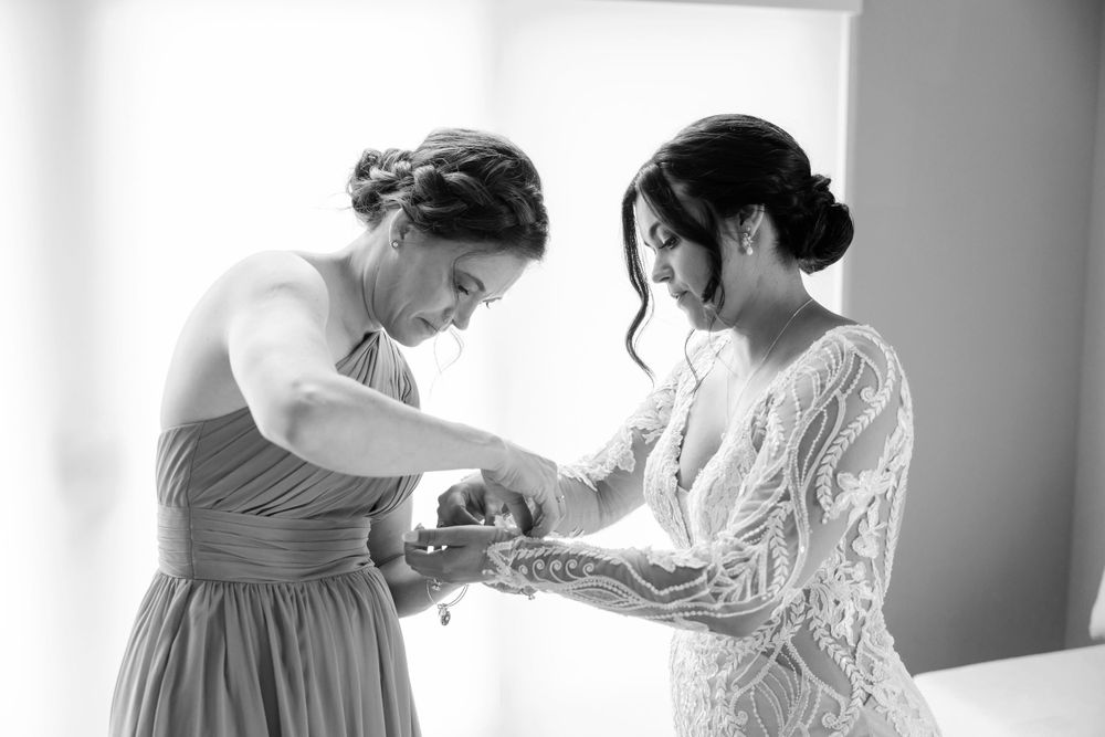 Maid of honor helping bride get ready for wedding ceremony at Jorgensen Farms in Westerville, Ohio.
