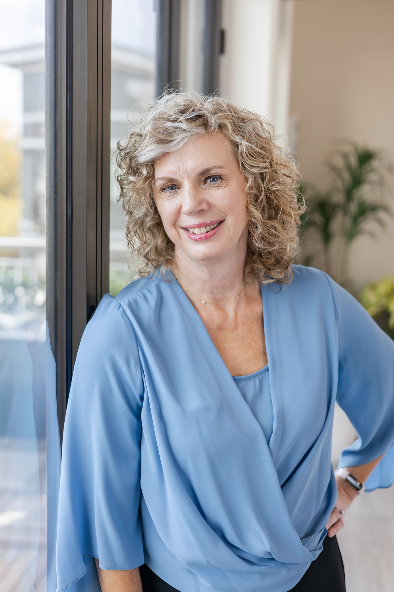 woman in blue shirt next to window for headshots True Fit College Counseling  in Woodinville, WA