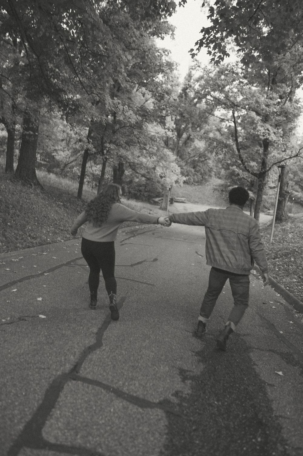 A black and white photo of a couple walking together on a winding path.