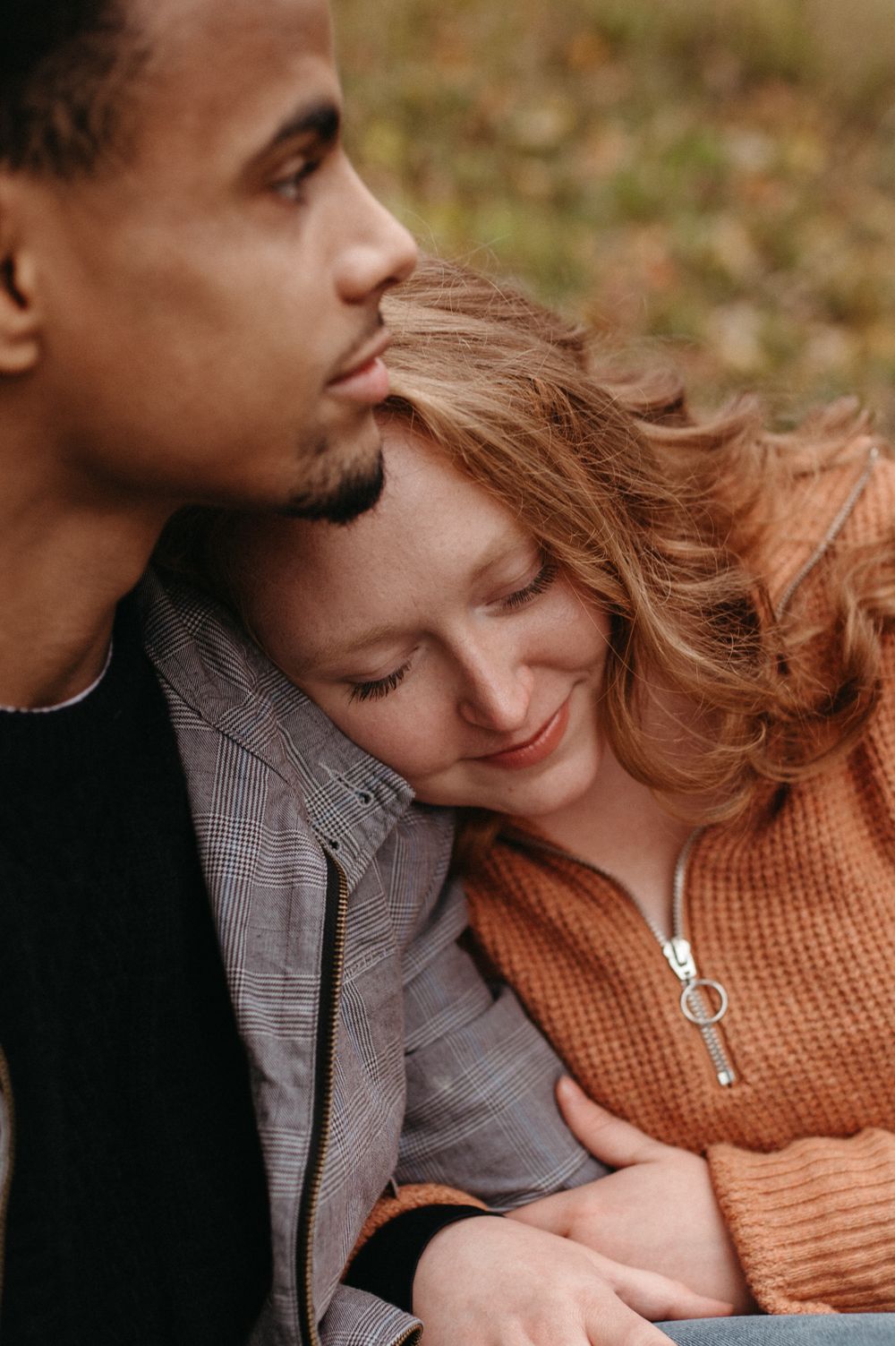 A tender close-up moment between a couple in warm autumn lighting.