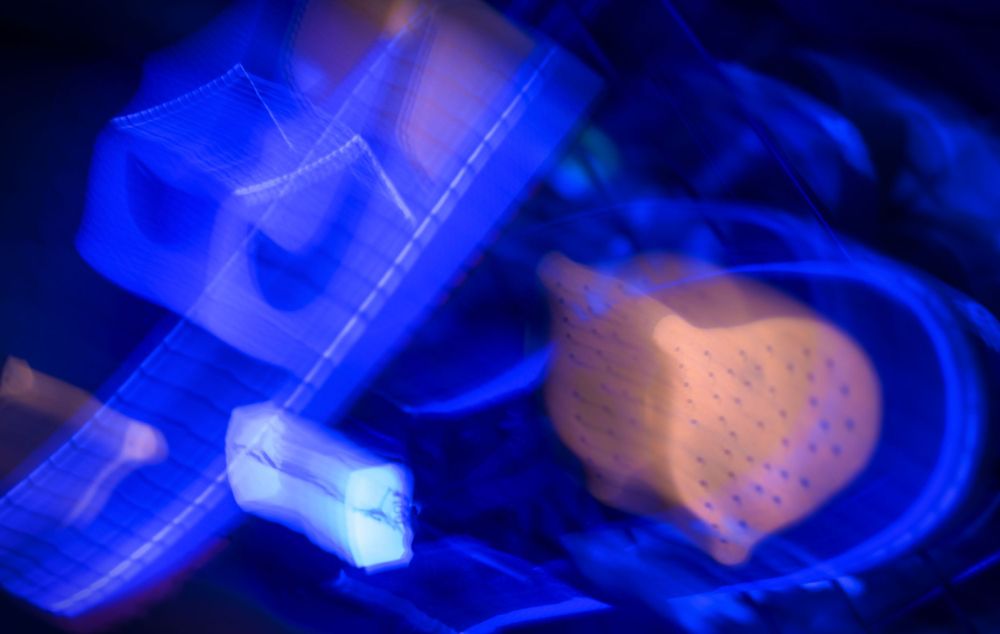 Abstract blue light trails creating ethereal patterns in darkness.