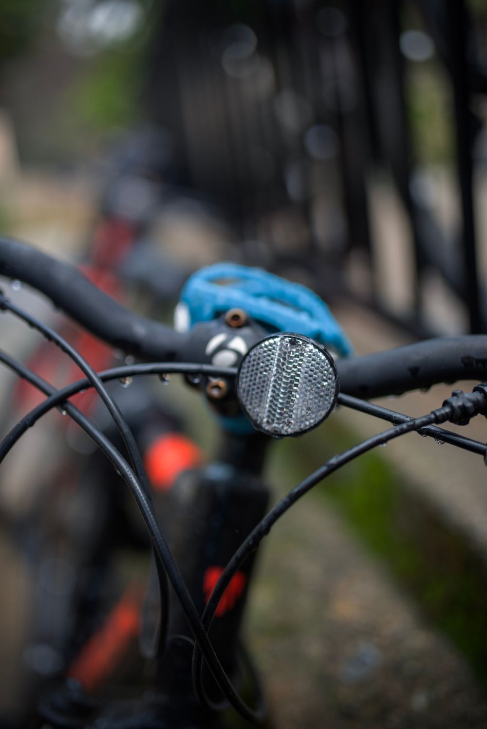 Close-up of a bicycle headlight reflector and handlebars with blurred background.