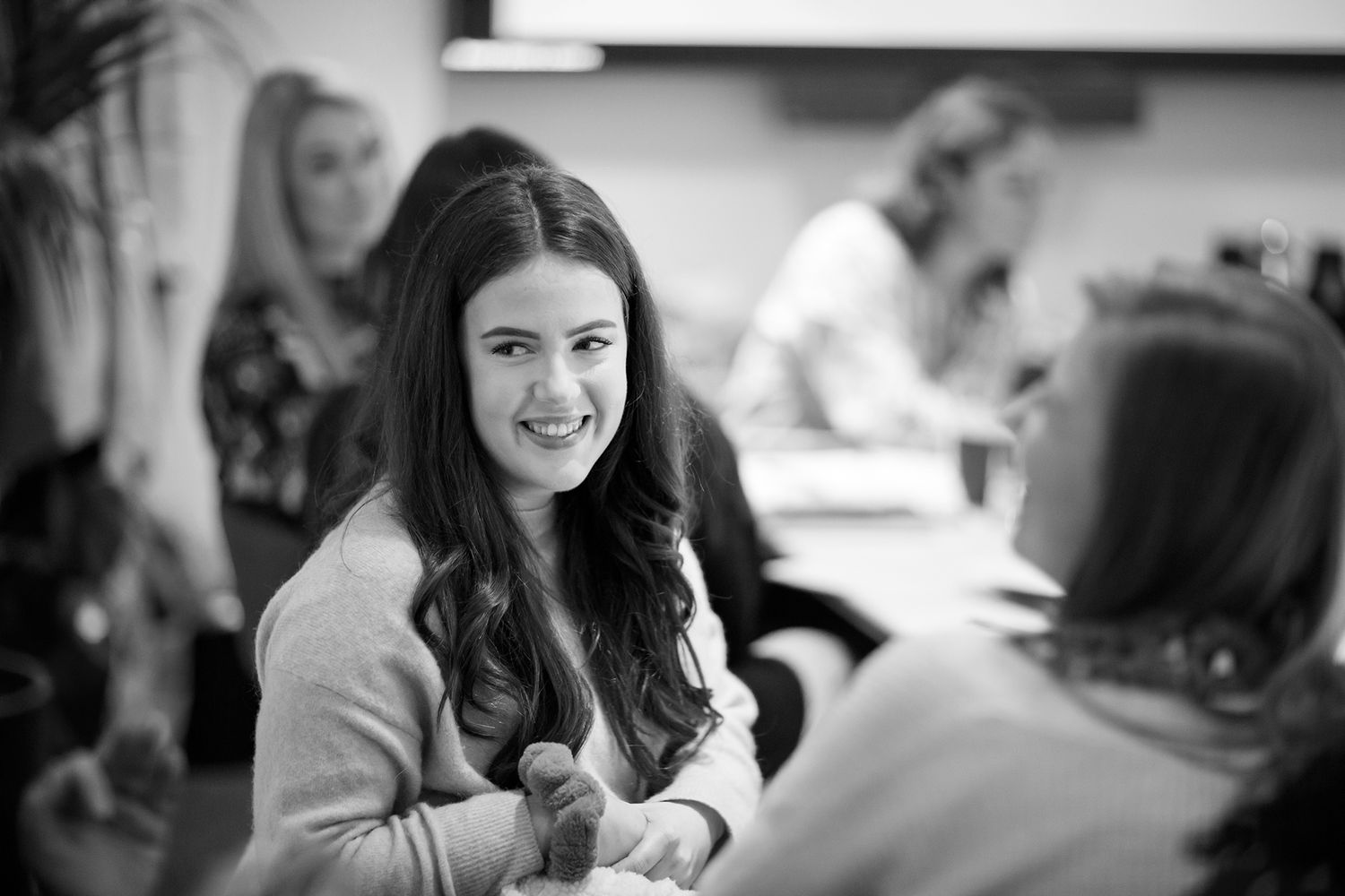 Black and white candid photo of a person smiling during a meeting or work session during business branding photoshoot.