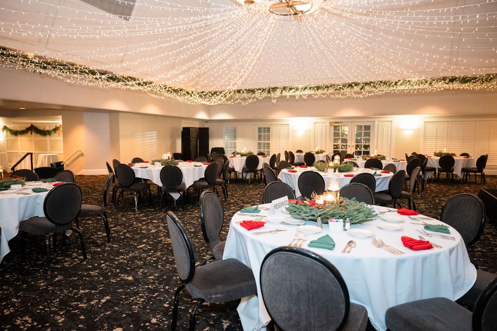 An elegant banquet hall decorated with twinkling lights and white tablecloths set for a formal event.