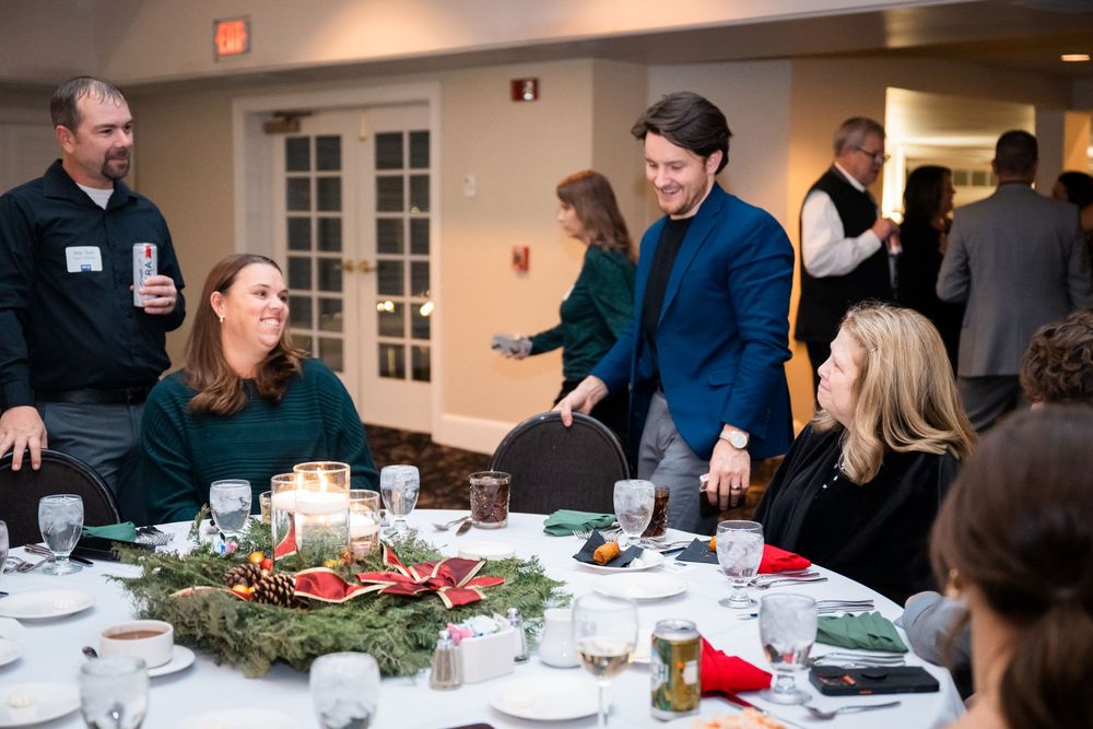 People gathered around a decorated holiday dinner table at a festive celebration event.