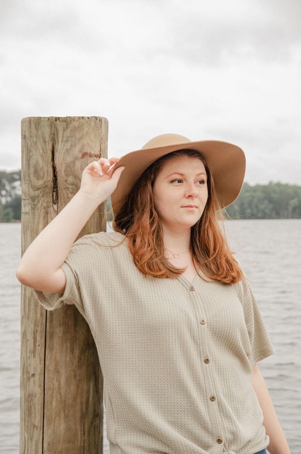 Girl stands on dock with a hat in Lake Murray, SC