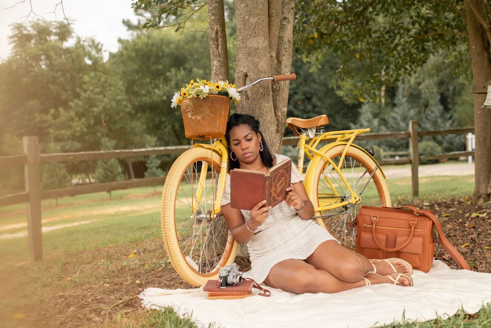 Girl sitting with yellow bike reading a book in Gilbert, SC